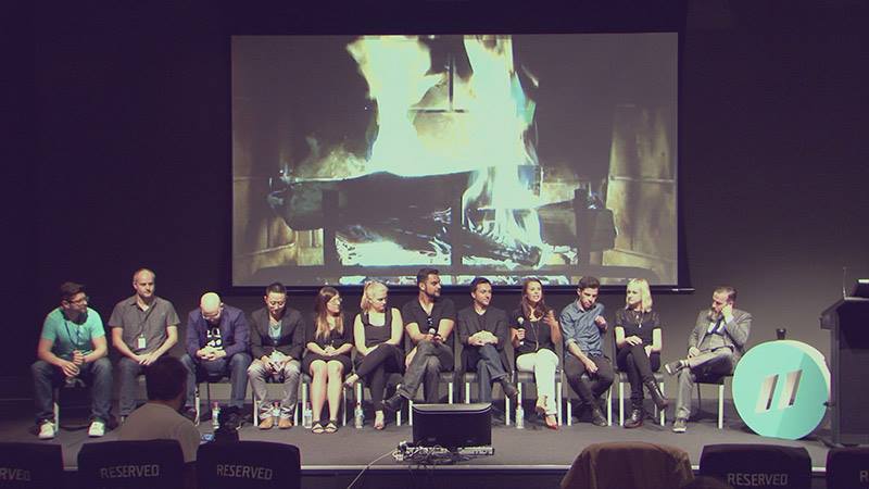 Panel of speakers seated on stage at an industry event