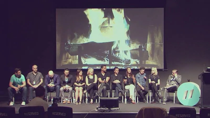 Panel of speakers seated on stage at an industry event