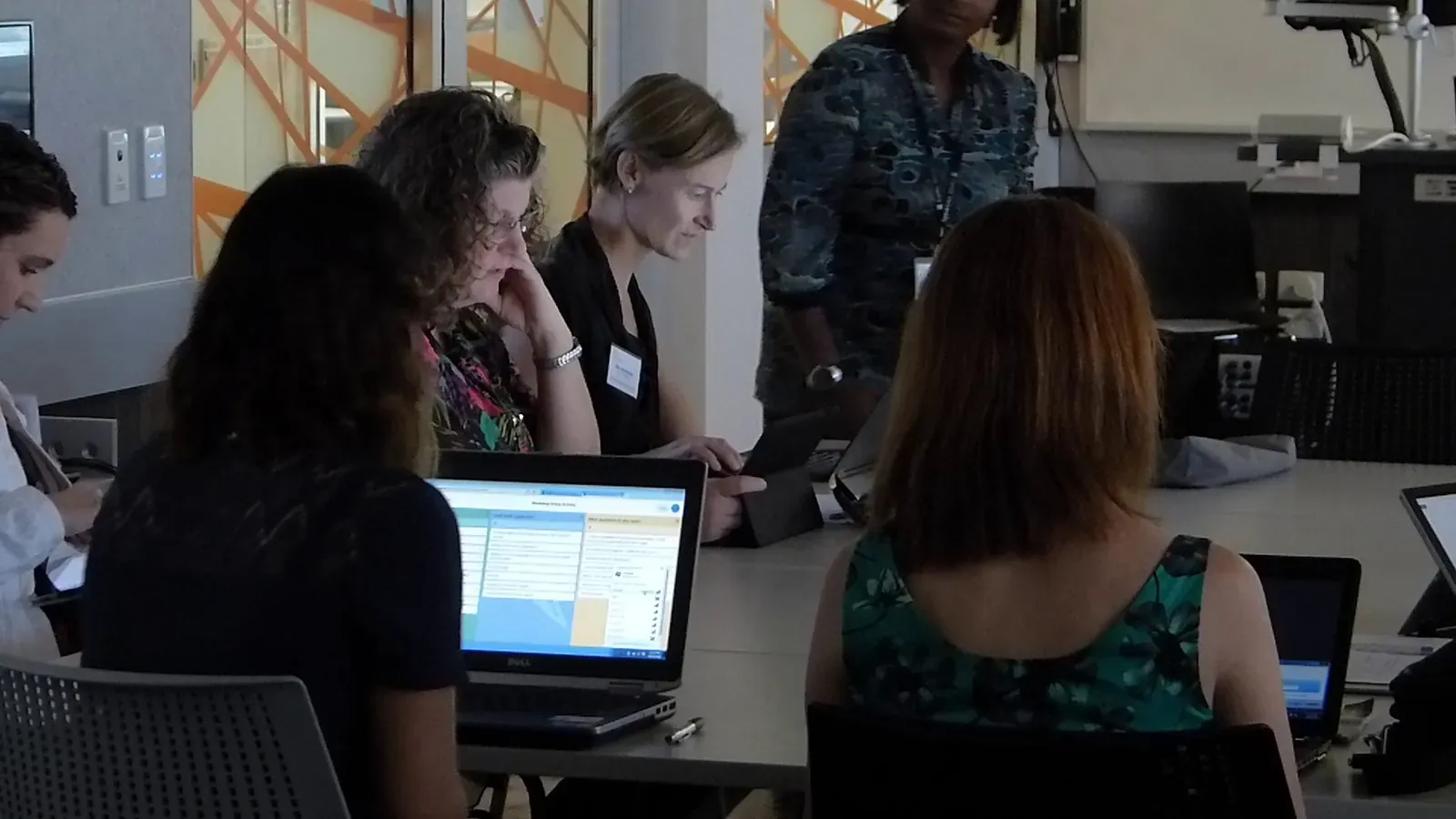 Workshop participants working together on laptops at a table