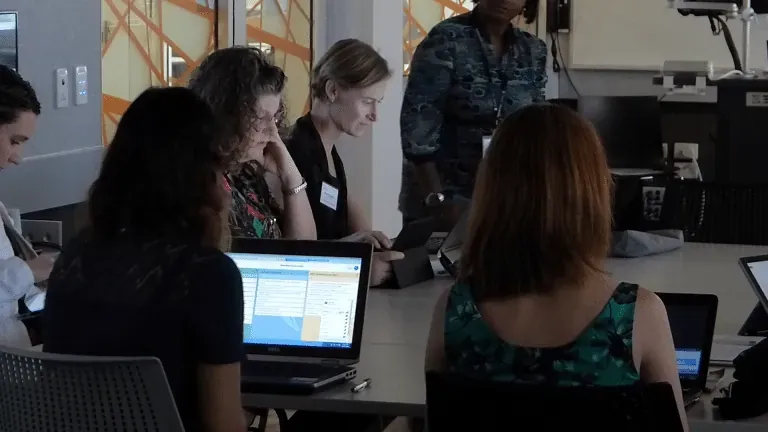 Educators collaborating on laptops in a teaching forum