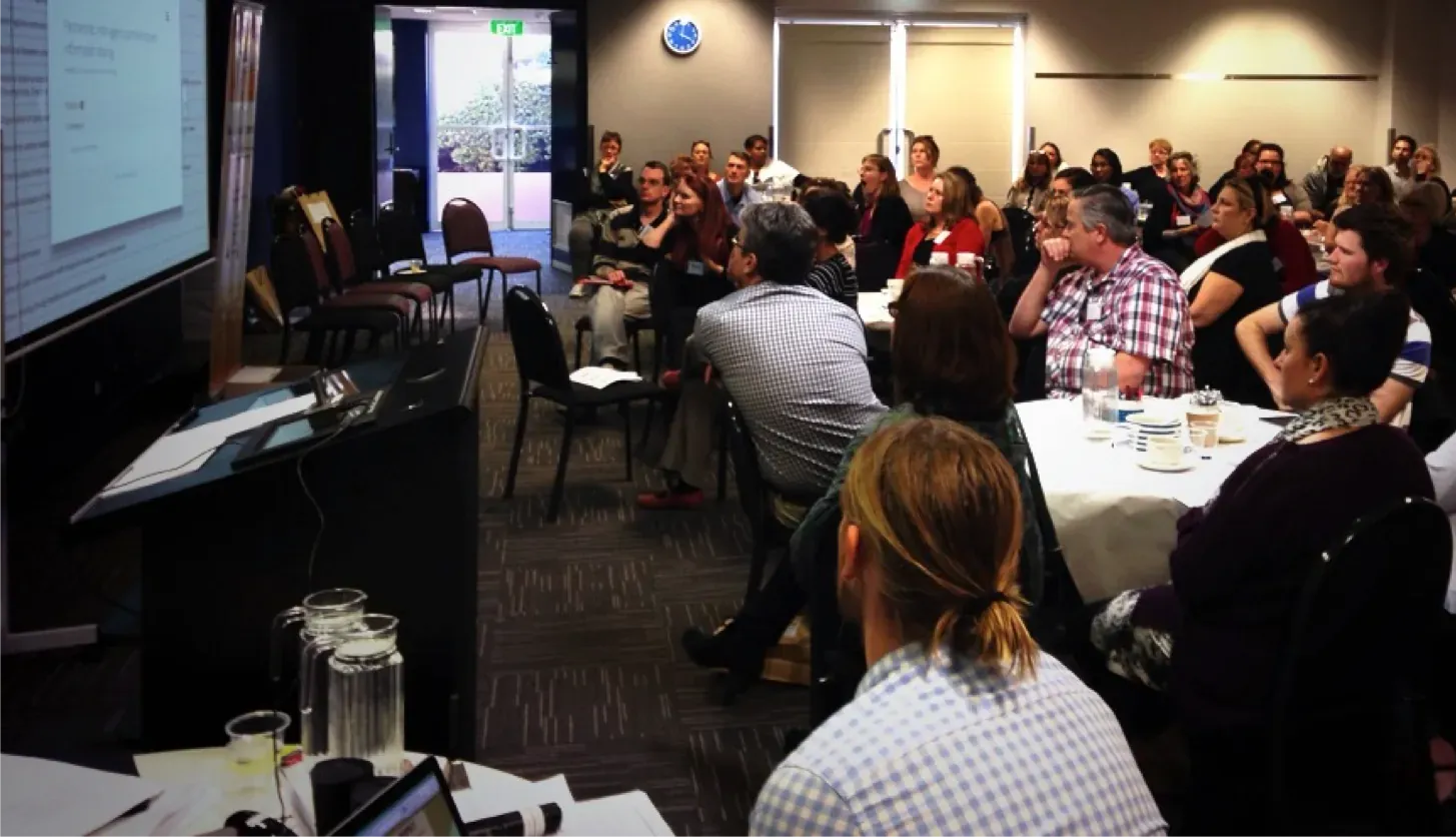 Audience seated in a conference room watching a presentation