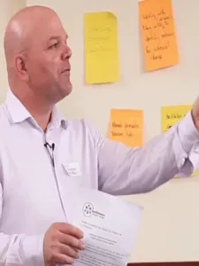 Andrew Huffer facilitating a workshop beside sticky notes on the wall