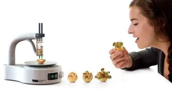 A 3D food printer creating edible finger foods as a woman tastes one