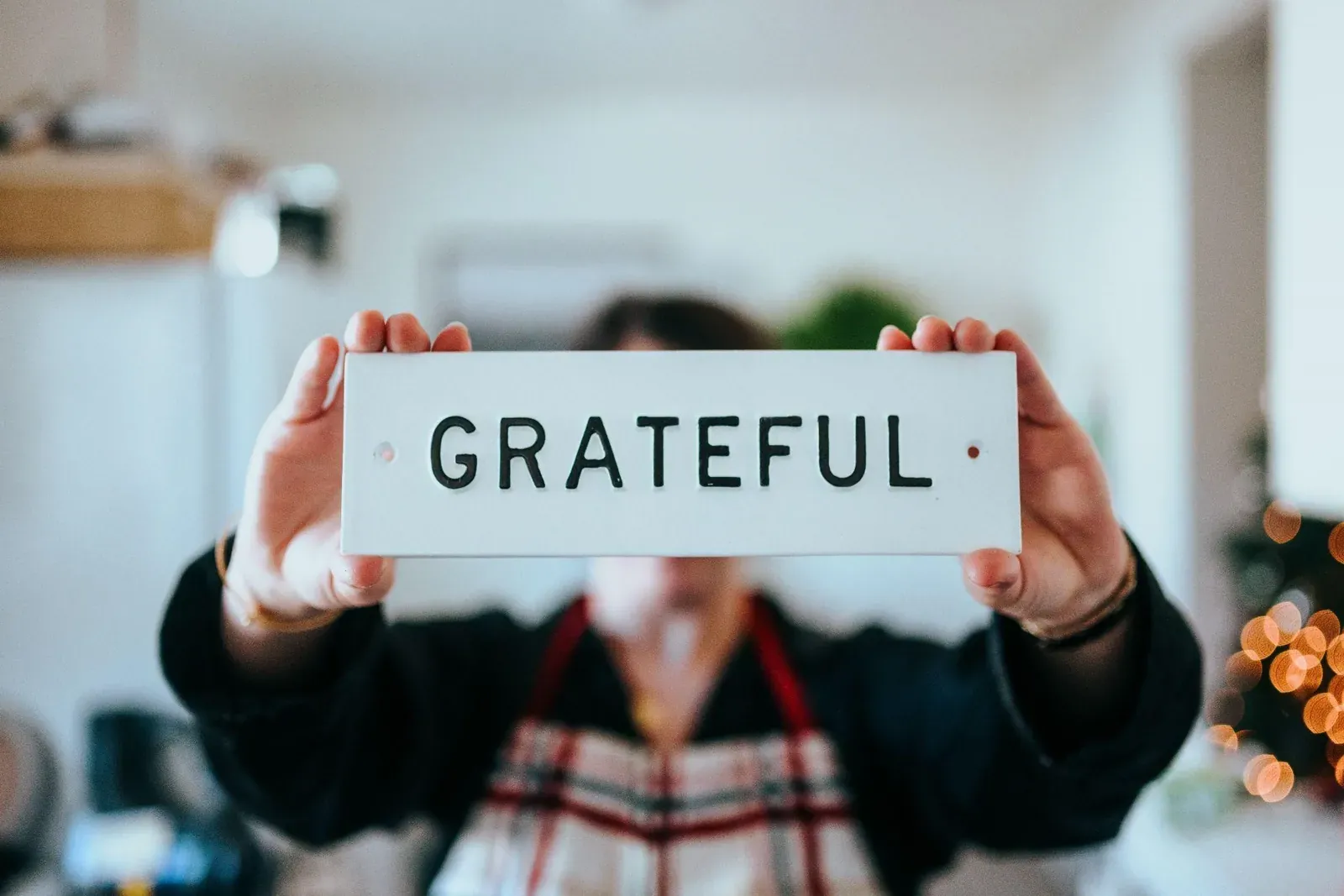 Person holding up a sign that reads grateful