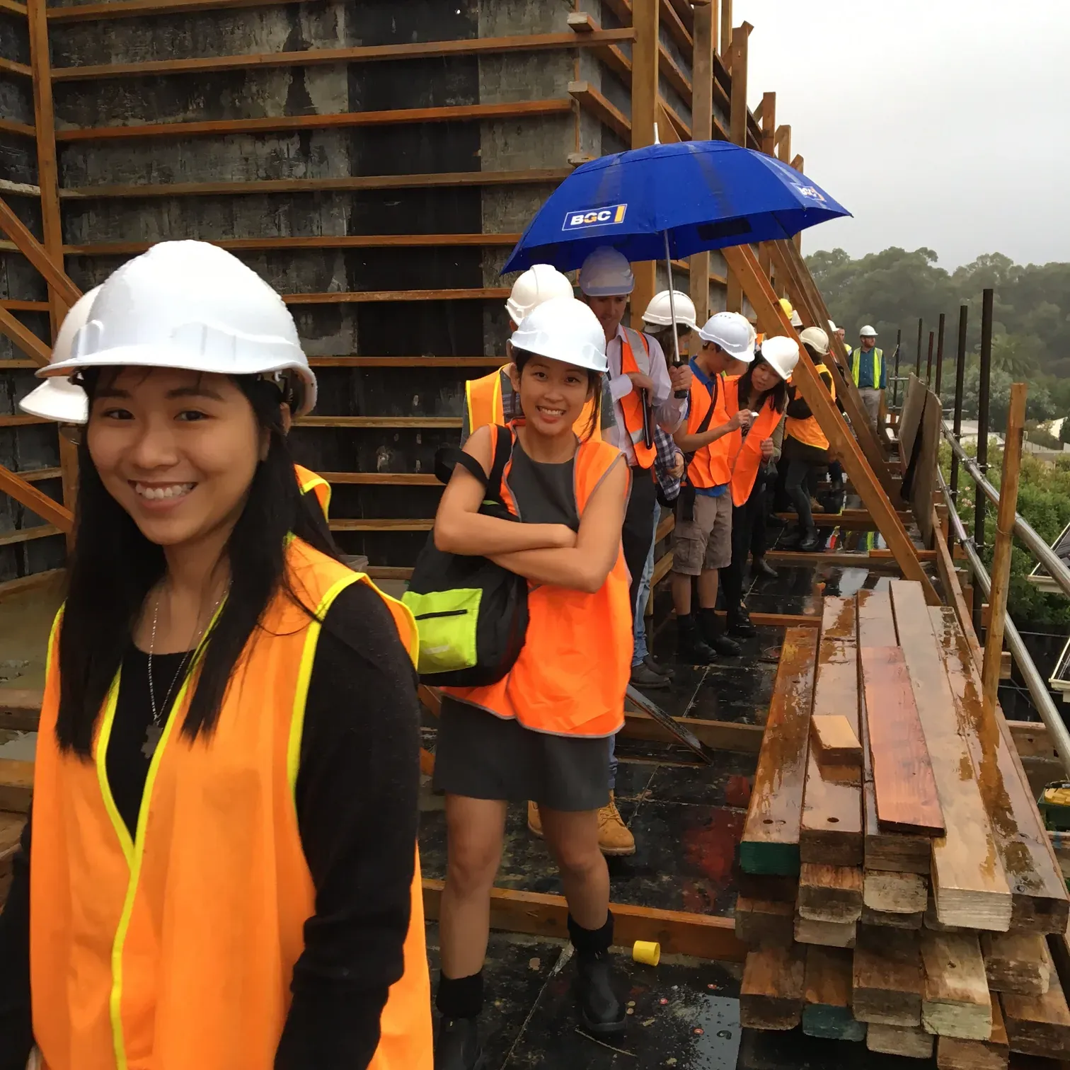 Architecture students in hi-vis gear on a rainy site visit