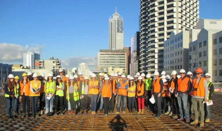 Students in hard hats and hi-vis vests on a city site visit