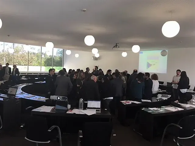 Delegates standing and discussing in groups during the forum session