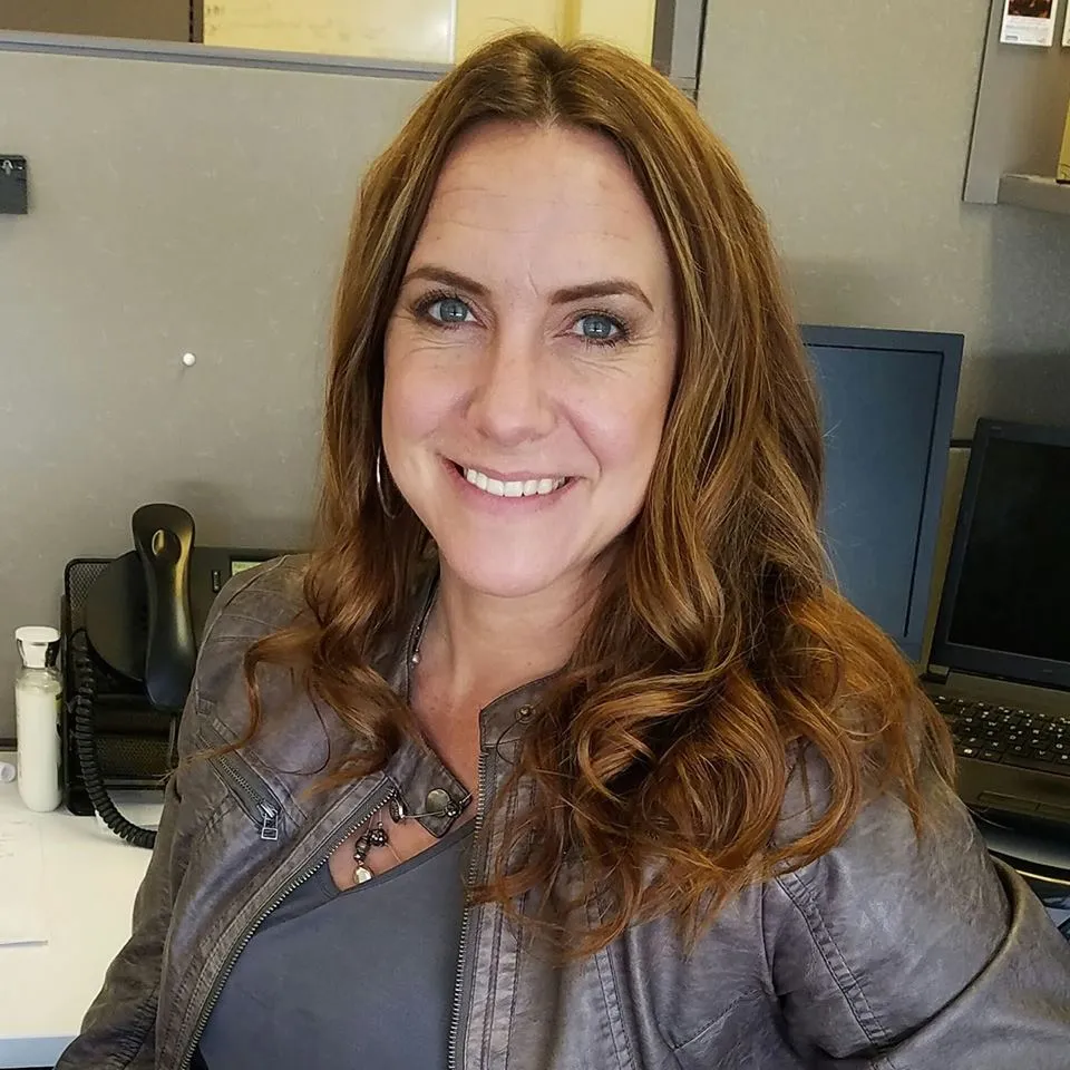 Continuous improvement manager smiling at her office workstation