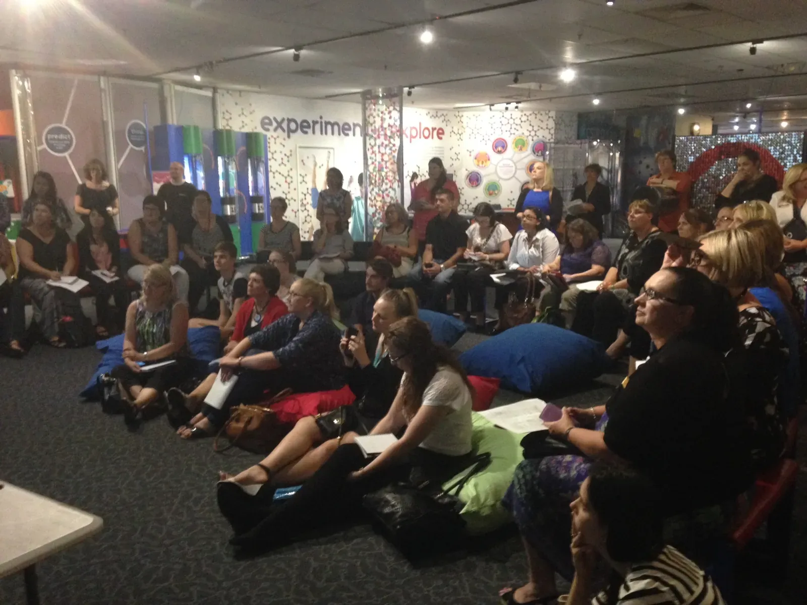 Audience seated at a science center event listening to a presentation