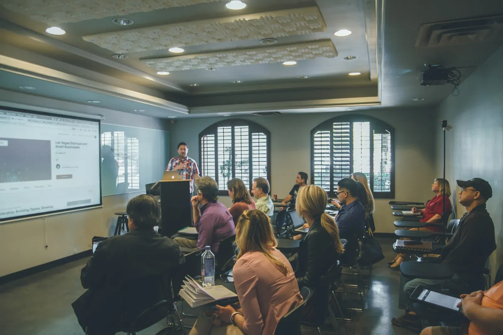 Presenter speaking to a seated audience at a workshop