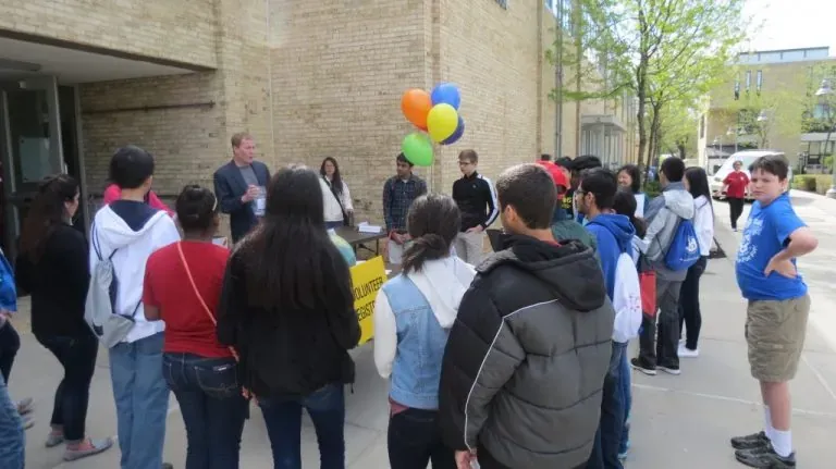 Young participants gathering outdoors around a sign-up table at a Rockville Science Center event