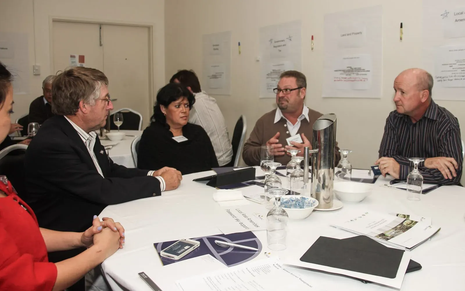 Participants in discussion around a table at a council workshop